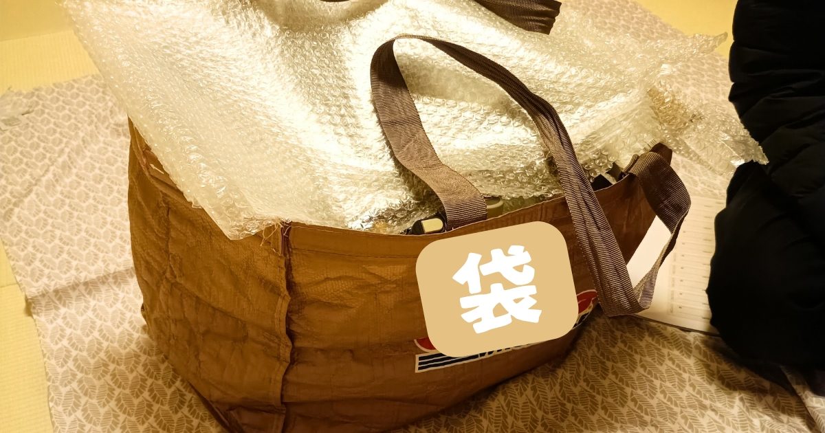 買い取った品物でいっぱいになった査定士さんの鞄